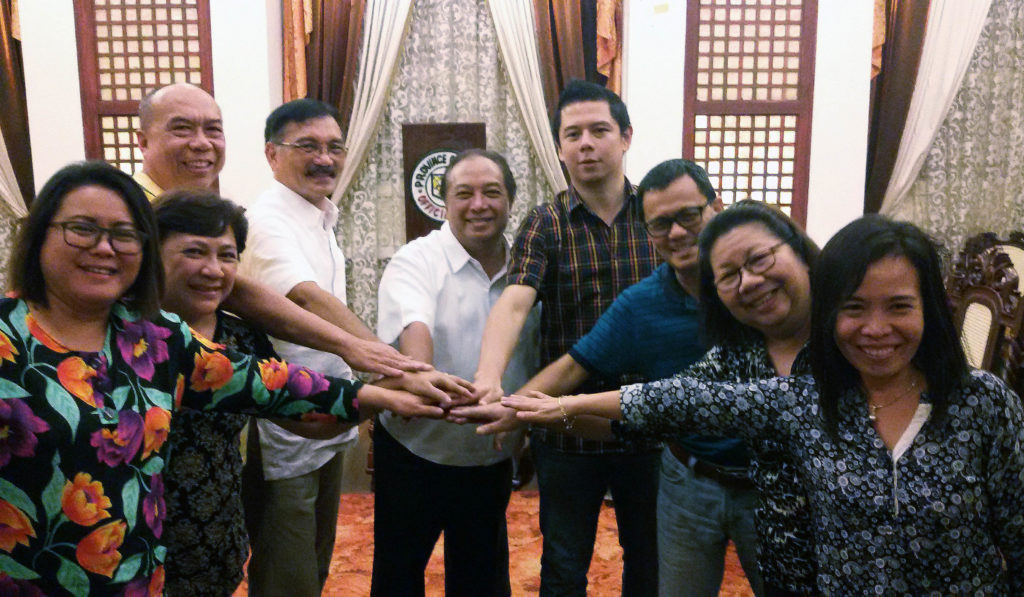 Tripartite partners strike an “all of one, one for all” pose to symbolize a solid partnership.